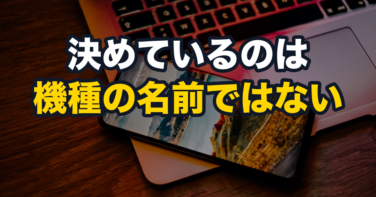 ノートパソコンの上に置かれたスマートフォンに、風景の写真が映っている